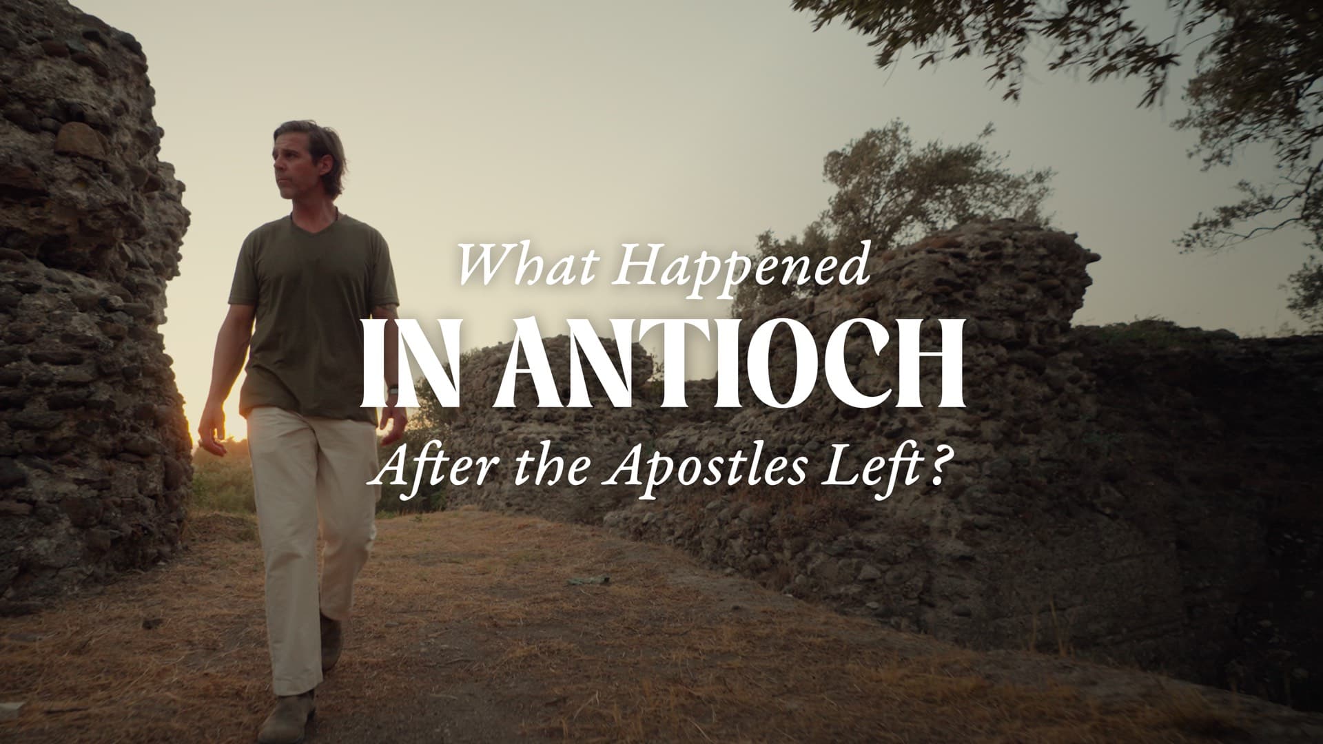 A man walking a path between ancient stone ruins in Antioch at sunset